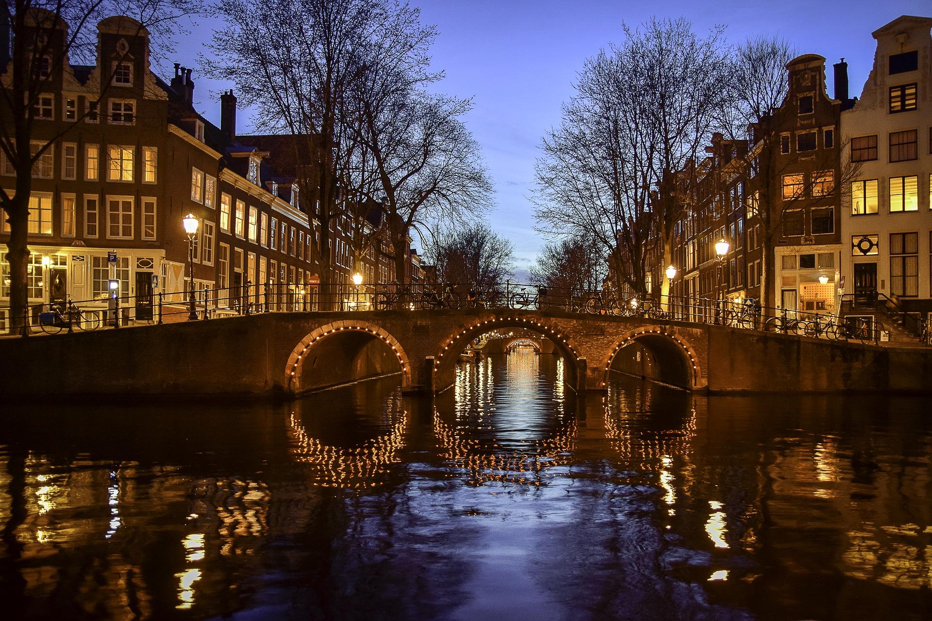 Beleuchteter Kanal in Amsterdam bei Nacht